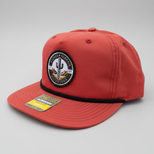 Red cap with a patch and brand label on a stone surface