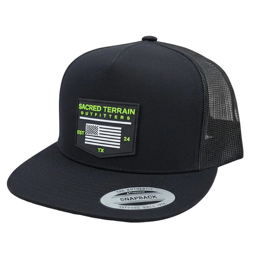 Black snapback cap with a label on a stone surface