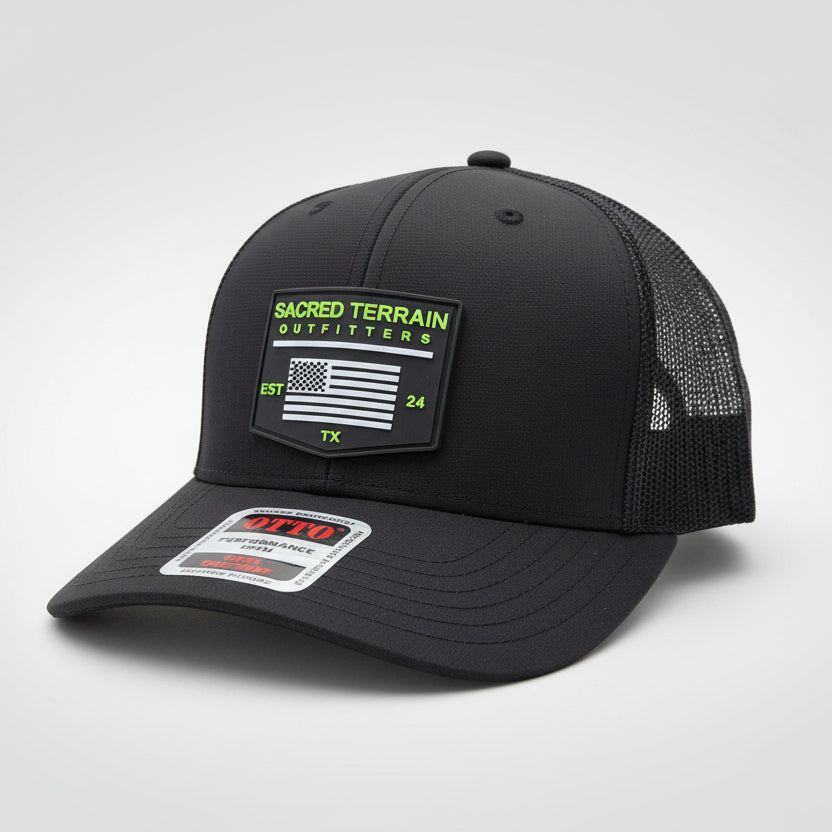 Black cap with mesh back and visible branding on a stone surface