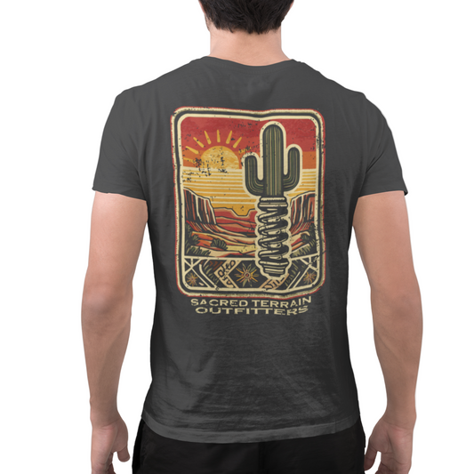 Person wearing a black t-shirt with a cactus design and 'Sacred Terrain Outfitters' text on the back.